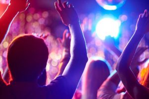 Tanzende Menschen mit erhobenen Armen in einer Disco